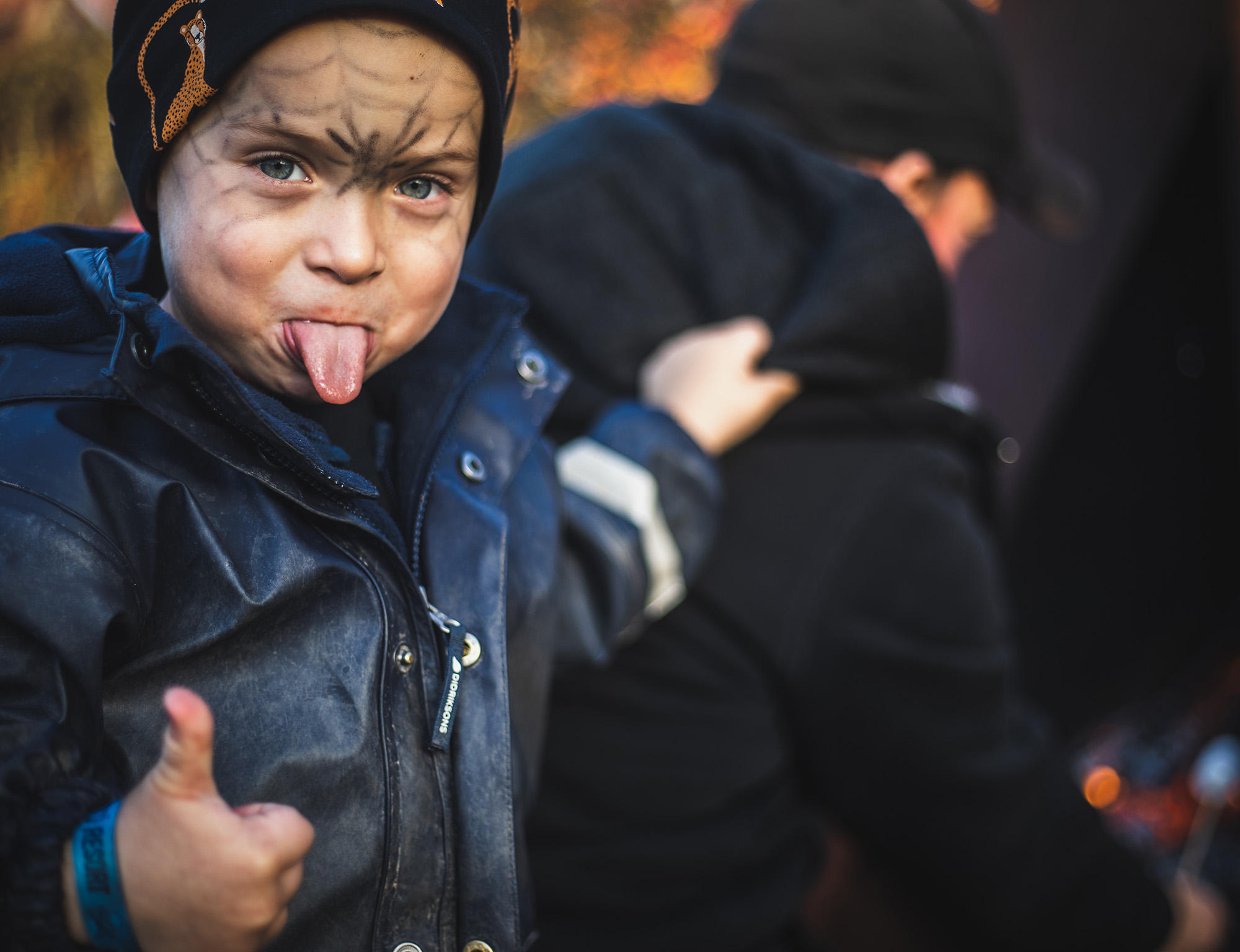 barn som räcker ut tungan och visar tummen upp