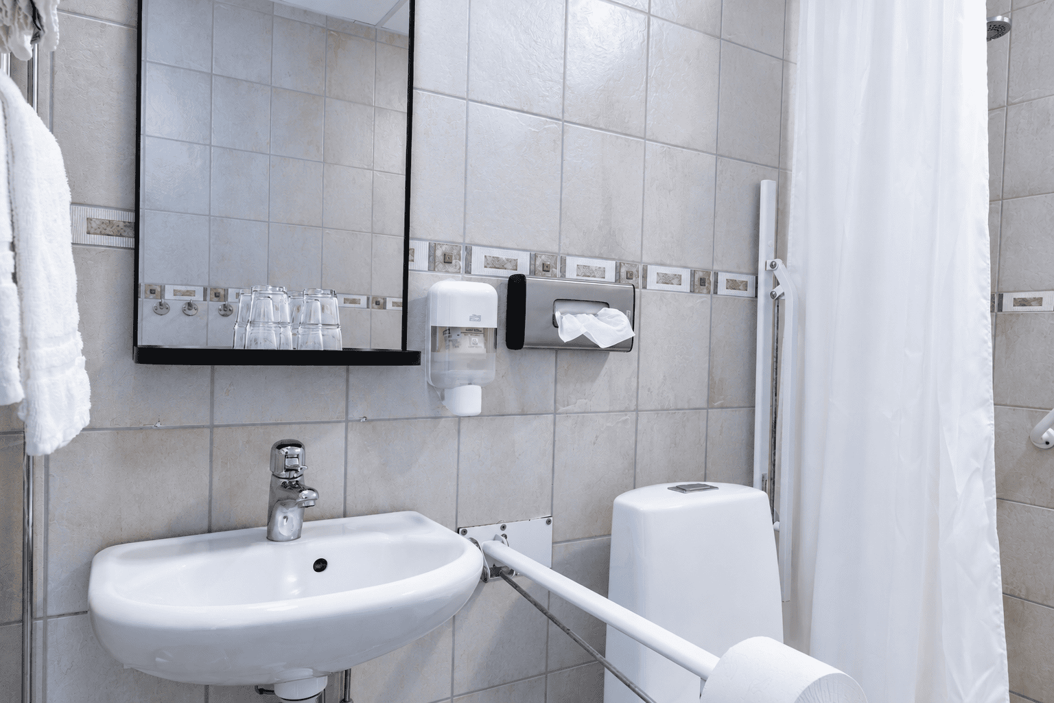 Modernt tillgangligt badrum med mosaik kakelrand